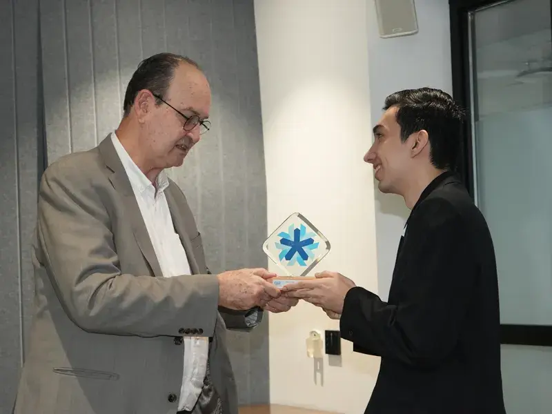 El padre Vicente Durán Casas, SJ, entrega a Santiago Valencia, estudiante de Derecho, el premio al Mejor estudiante de Consultorio Jurídico 2025